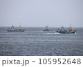 荒波の中出漁していく漁船団 105952648