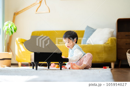 リビングでおもちゃのピアノを弾く3歳の男の子 リビングでおもちゃのピアノを弾く3歳の男の子 105954027