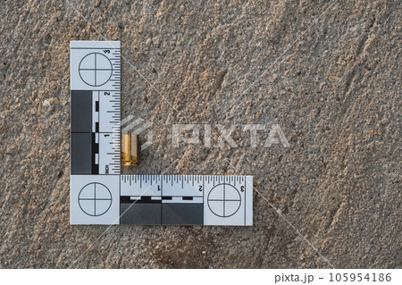 One crime scene evidence ruler on the street after a gun shooting brass bullet shell casing 9mm handgun pistol 105954186