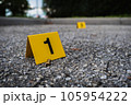 A group of yellow crime scene evidence markers on the street after a gun shooting brass bullet shell casing rifle 105954222