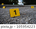 A group of yellow crime scene evidence markers on the street after a gun shooting brass bullet shell casing rifle 105954223