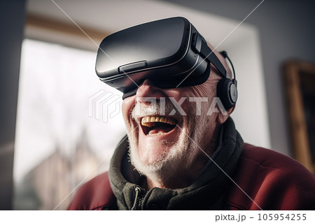 An older man is seen laughing while using a virtual reality headset. An older man is seen laughing while using a virtual reality headset. 105954255