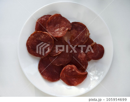 Meat chips on a plate. Dried pieces of meat. Meat chips on a plate. Dried pieces of meat. 105954699