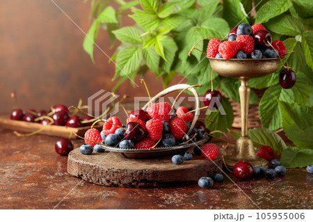 Berries with leaves on an old brown table. 105955006