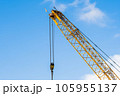 A yellow crane at a construction site during a sunny day 105955137