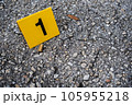 One yellow crime scene evidence marker on the street after a gun shooting brass bullet shell casing 9mm handgun pistol 105955218