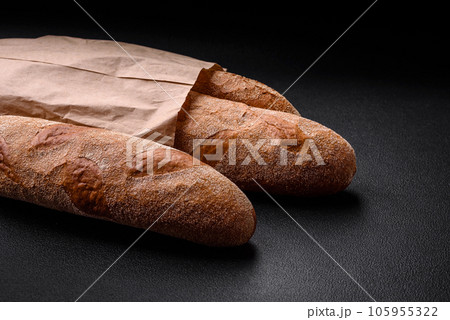 French baguette bread on a dark textured concrete background French baguette bread on a dark textured concrete background 105955322