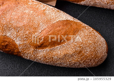 French baguette bread on a dark textured concrete background French baguette bread on a dark textured concrete background 105955329