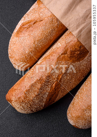 French baguette bread on a dark textured concrete background French baguette bread on a dark textured concrete background 105955337
