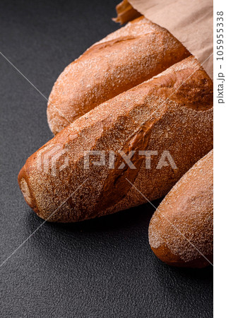 French baguette bread on a dark textured concrete background French baguette bread on a dark textured concrete background 105955338