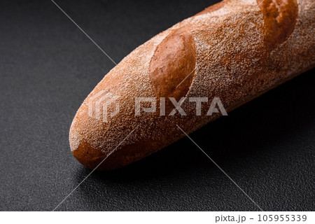 French baguette bread on a dark textured concrete background French baguette bread on a dark textured concrete background 105955339