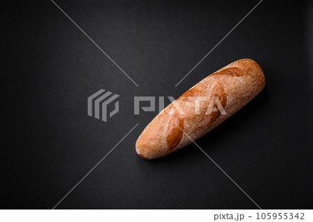 French baguette bread on a dark textured concrete background 105955342