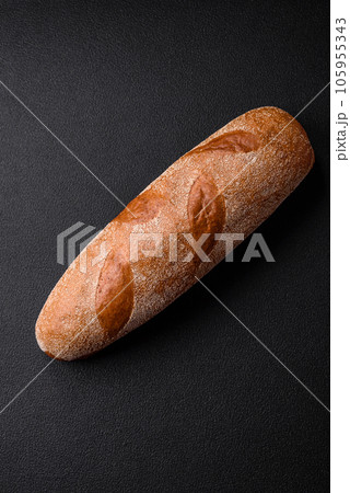 French baguette bread on a dark textured concrete background 105955343