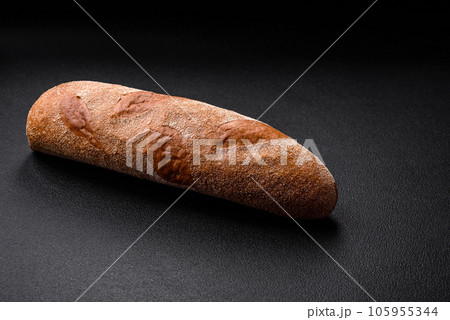 French baguette bread on a dark textured concrete background 105955344