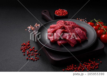 Juicy fresh raw beef meat with salt, spices and herbs Juicy fresh raw beef meat with salt, spices and herbs 105955390