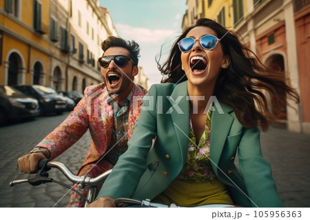 Couple on bike together riding in a city Couple on bike together riding in a city 105956363