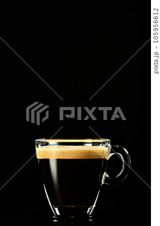 Espresso on a dark background. Coffee for breakfast in an Italian cafe shop, vertical shot, selective focus 105956612