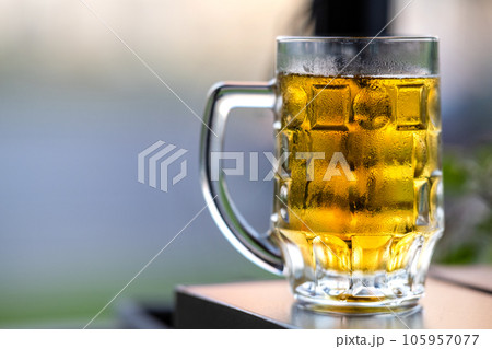 Glass of light beer on a wooden table in a restaurant 105957077