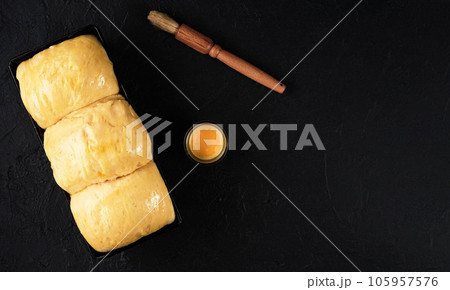 Brioche dough on a tray proofing dough before baking. Baked concept. Top view with copy space 105957576