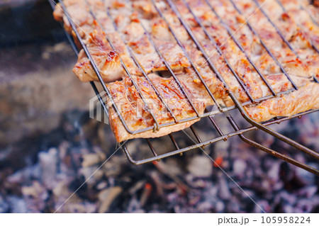 pieces of turkey meat on the grill grate.  105958224