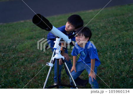 天体望遠鏡を覗く男子小学生 105960134