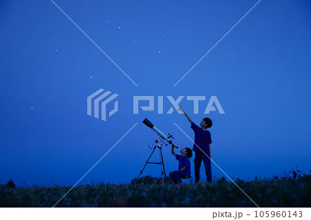 夜空のもとで天体観測をする小学生の男の子 夜空のもとで天体観測をする小学生の男の子 105960143