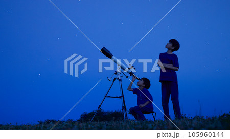 夜空のもとで天体観測をする小学生の男の子 夜空のもとで天体観測をする小学生の男の子 105960144
