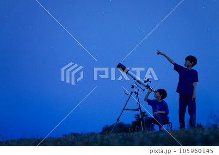 夜空のもとで天体観測をする小学生の男の子 夜空のもとで天体観測をする小学生の男の子 105960145