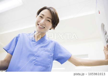 CT検査を受ける患者に優しく笑いかける放射線技師女性 105961013