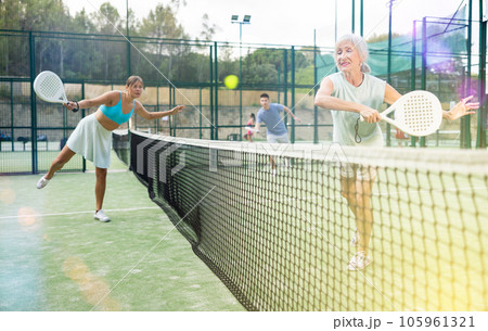 Women playing padel tennis match during training on court 105961321
