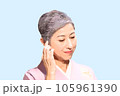 着物を着て髪に触れるグレイヘアの中年女性 105961390