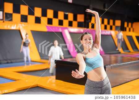 Young woman trains jumping in trampoline center Young woman trains jumping in trampoline center 105961438