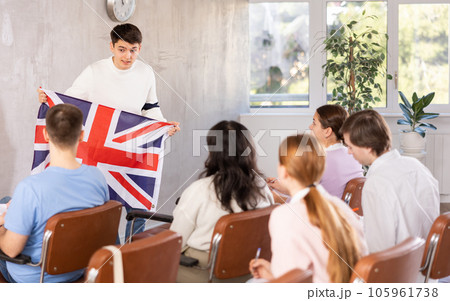 Young male professor showing british flag to group of students Young male professor showing british flag to group of students 105961738