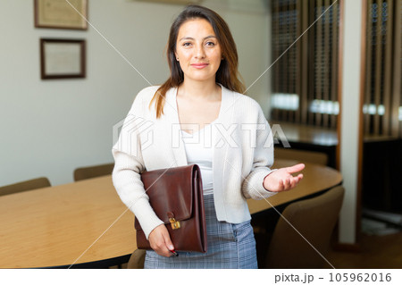 Positive businesswoman with briefcase for documents in office 105962016