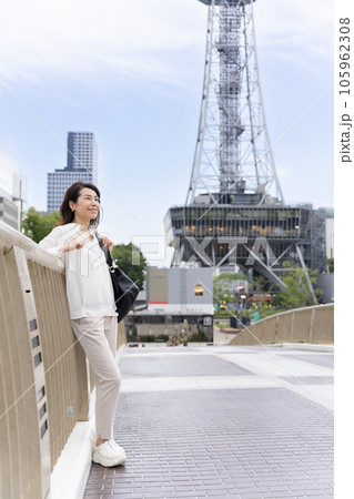 セントラルブリッジの上で、テレビ塔を背景に街を眺めているアラフィフのビジネスウーマン女性 105962308