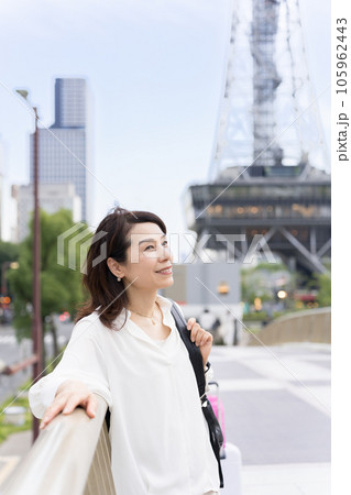 セントラルブリッジの上で、テレビ塔を背景に街を眺めているアラフィフのビジネスウーマン女性 セントラルブリッジの上で、テレビ塔を背景に街を眺めているアラフィフのビジネスウーマン女性 105962443