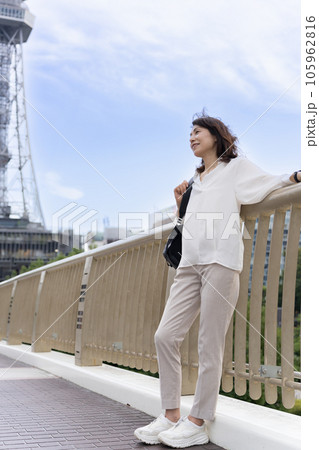 セントラルブリッジの上で、テレビ塔を背景に街を眺めているアラフィフのビジネスウーマン女性 105962816