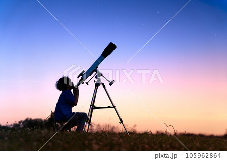 黄昏時の野原で天体観測をする少年 105962864