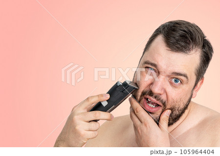 unshaven young man perfect skin hold electric razor shaving, isolated. Grooming for the modern man 105964404