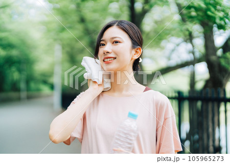 屋外で汗を拭く女性 屋外で汗を拭く女性 105965273