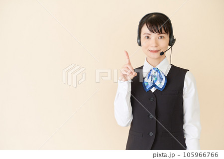 ヘッドセットをするベストにリボンタイの制服を着た、受付業務、事務業務の女性 ヘッドセットをするベストにリボンタイの制服を着た、受付業務、事務業務の女性 105966766