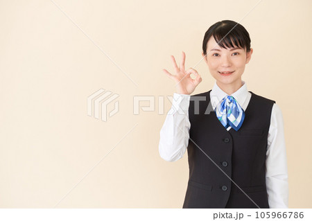 OKサインを出すベストにリボンタイの制服を着た、受付業務、事務業務の女性 OKサインを出すベストにリボンタイの制服を着た、受付業務、事務業務の女性 105966786