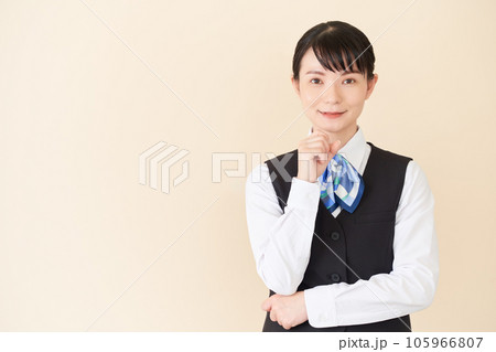 顎に手を当てるベストにリボンタイの制服を着た、受付業務、事務業務の女性 顎に手を当てるベストにリボンタイの制服を着た、受付業務、事務業務の女性 105966807