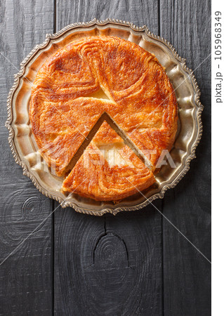 Kouign amann is a round multi-layered cake containing with laminated dough soaked in butter and sugar closeup on the plate. Vertical top view Kouign amann is a round multi-layered cake containing with laminated dough soaked in butter and sugar closeup on the plate. Vertical top view 105968349