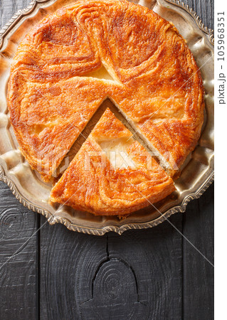 Kouign-amann a sweet Breton cake made with laminated dough closeup on the plate on the table. Vertical top view Kouign-amann a sweet Breton cake made with laminated dough closeup on the plate on the table. Vertical top view 105968351