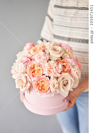 Florist woman creates flower arrangement in a round box. Beautiful bouquet of mixed flowers. Floral shop concept . Handsome fresh bunch. Flowers delivery Florist woman creates flower arrangement in a round box. Beautiful bouquet of mixed flowers. Floral shop concept . Handsome fresh bunch. Flowers delivery 105971451