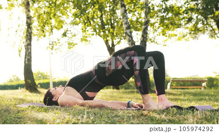 Athletic fitness girl doing an exercises on a mat on a grass Outdoors, body health concept 105974292