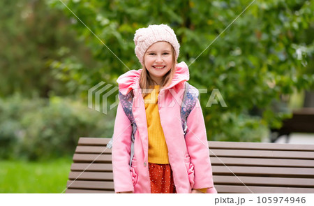 Pretty school girl kid with backpack smiling at autumn park. Beautiful female child portrait with blurred background Pretty school girl kid with backpack smiling at autumn park. Beautiful female child portrait with blurred background 105974946