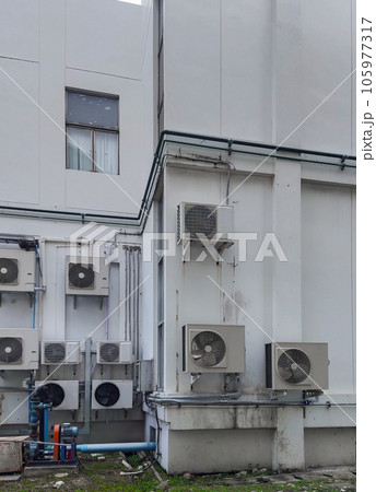 Multiple air conditioning units with fans on a office building exterior wall Multiple air conditioning units with fans on a office building exterior wall 105977317