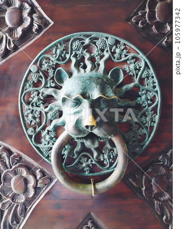 A door knocker is a fixture on the front door of a house. It is made of metal and has the form of a ring, which is knocked on the metal part of the door knocker fixed to the wall. Muzzle of a lion. A door knocker is a fixture on the front door of a house. It is made of metal and has the form of a ring, which is knocked on the metal part of the door knocker fixed to the wall. Muzzle of a lion. 105977342